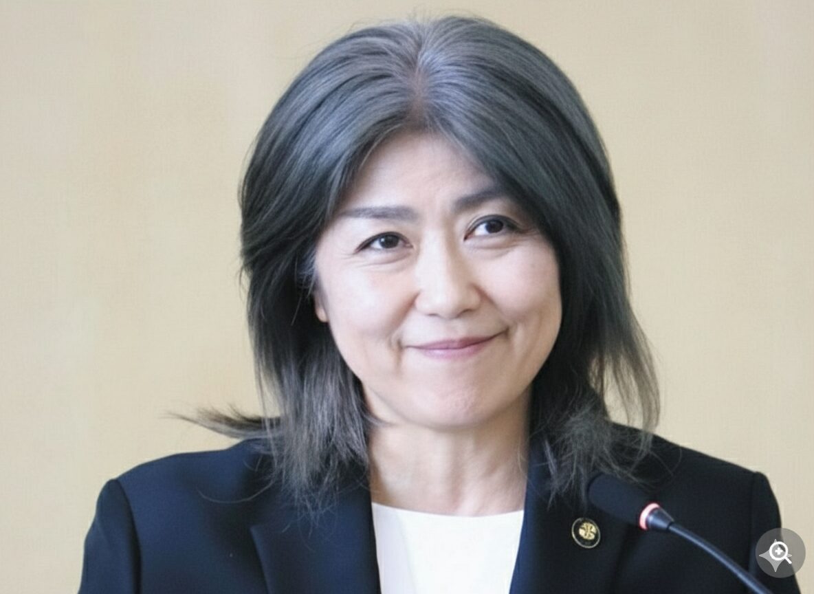 スーツ姿の女性が、口角を上げてにこやかに微笑んでいる顔写真。元の真顔の写真が、自然な笑顔の表情に加工されている。